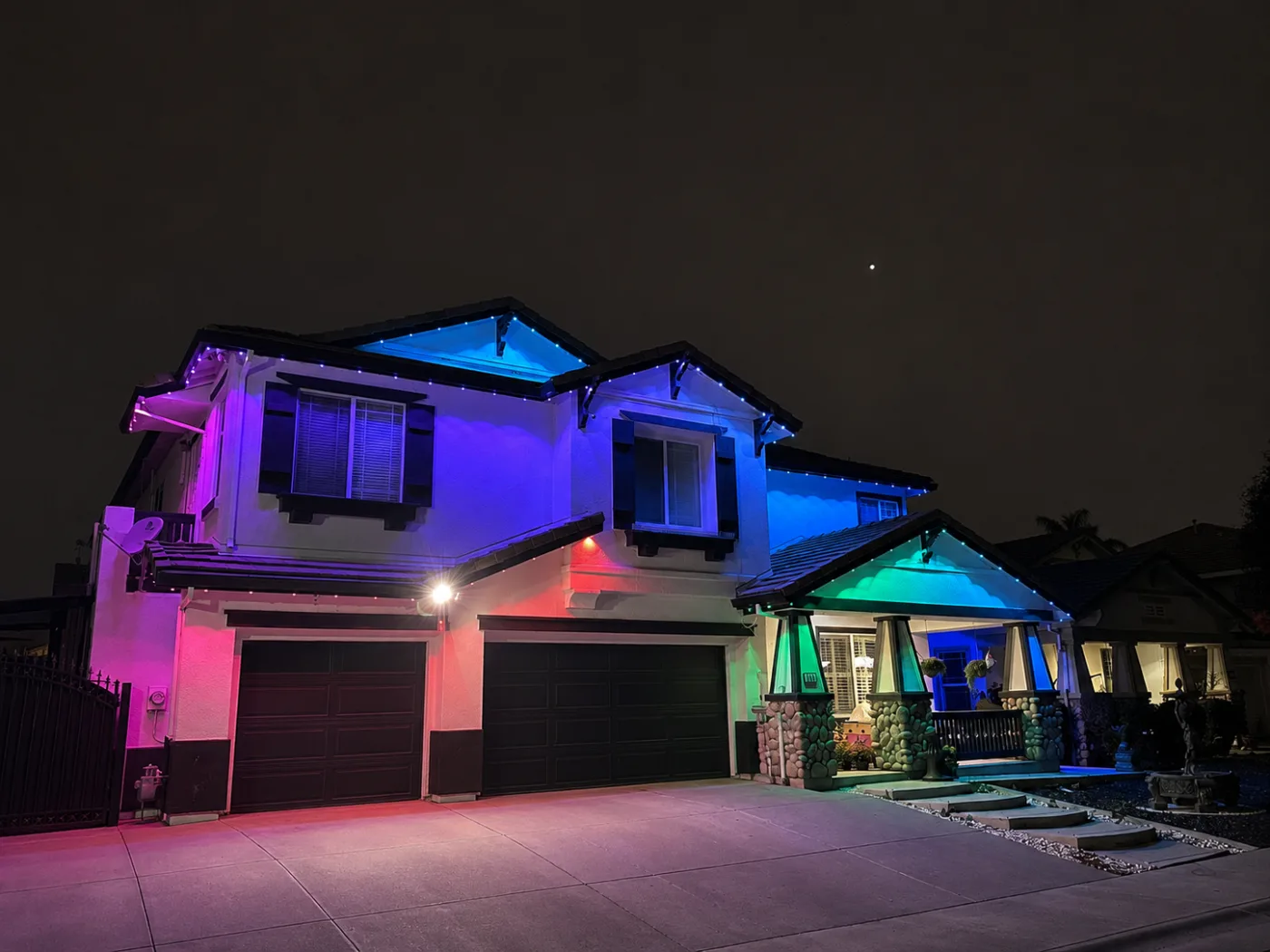 A two-story Sacramento home with its rooflines lit in color-changing LED for the holidays